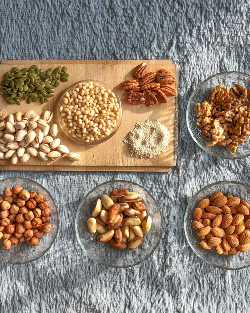 কাচের বাটিতে সাজানো কাজু, কাঠবাদাম, চিনাবাদাম ও আখরোট